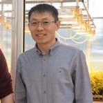 Dr. Zhang in front of a greenhouse 